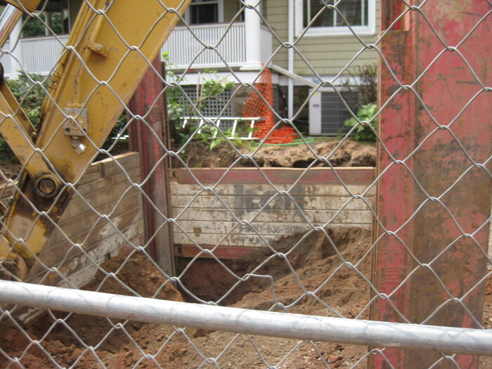 Excavator working within a fenced construction site