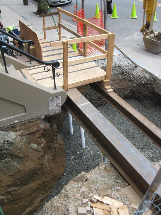 Wooden platform and I-beam support installed over an excavation site